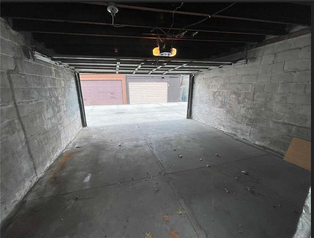 garage featuring a garage door opener and concrete block wall