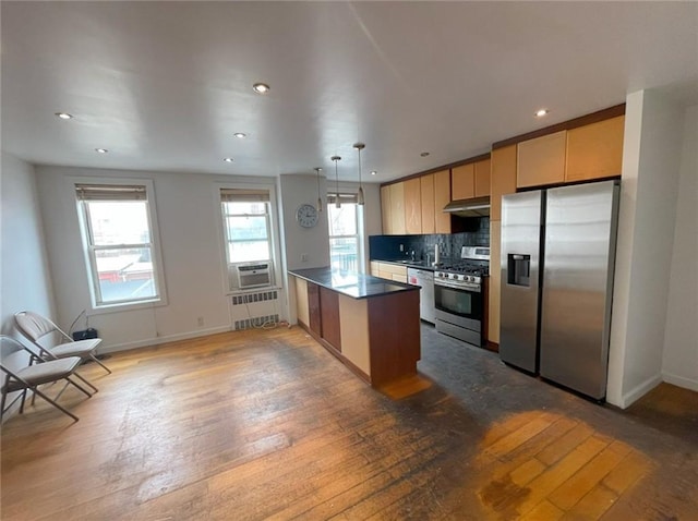kitchen featuring recessed lighting, wood-type flooring, stainless steel appliances, and a peninsula