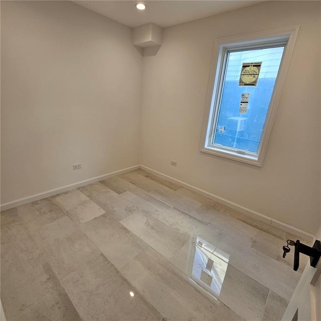 unfurnished room with baseboards and recessed lighting