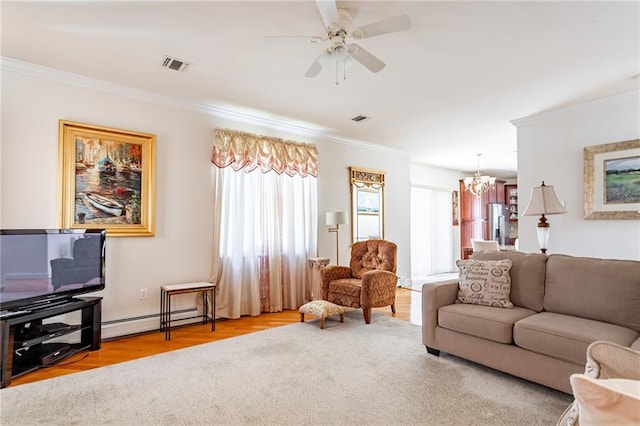 living room featuring visible vents, crown molding, baseboard heating, and a wealth of natural light