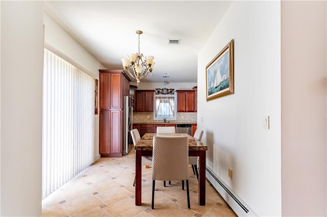 dining area featuring an inviting chandelier, a baseboard radiator, and visible vents