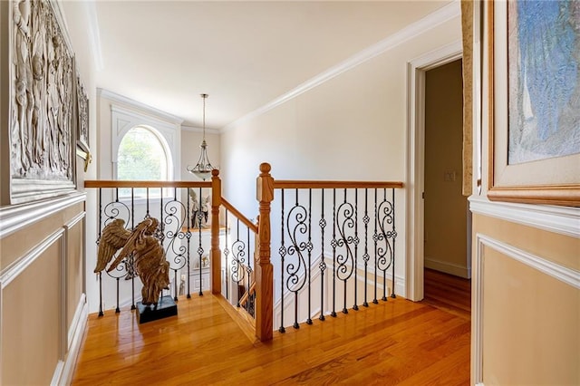 hallway featuring crown molding, an upstairs landing, and light wood-style floors