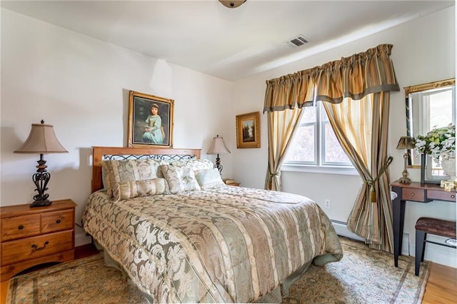 bedroom featuring multiple windows, wood finished floors, and visible vents