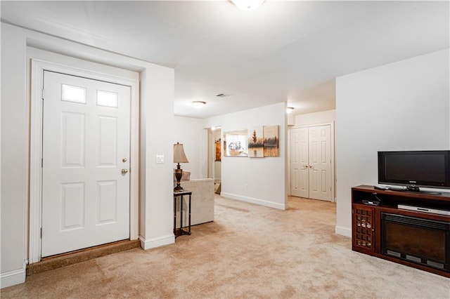 foyer featuring baseboards and carpet