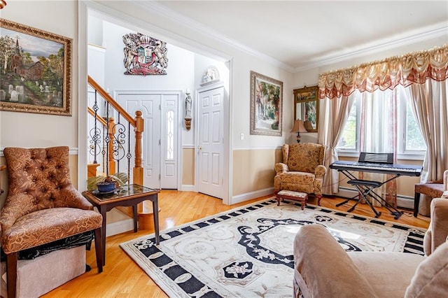 living area featuring crown molding, baseboards, stairs, and wood finished floors