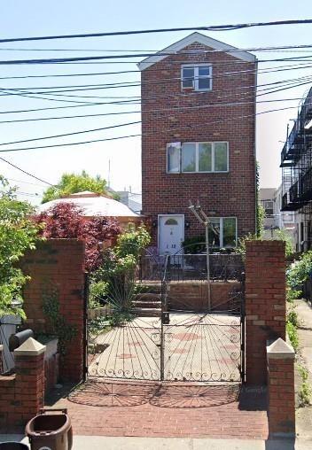 view of front of property with brick siding, a gate, and fence