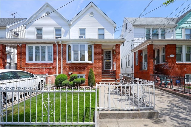 view of front of property with brick siding, a fenced front yard, and a front yard