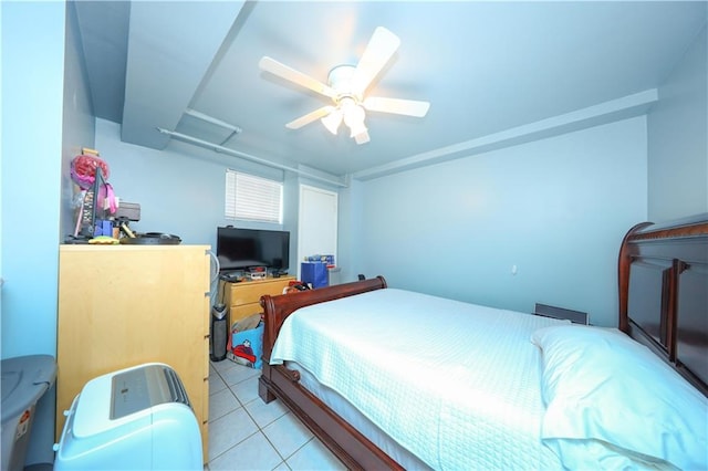 bedroom with a ceiling fan, light tile patterned floors, and attic access