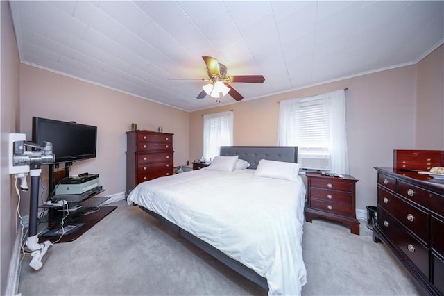 bedroom featuring light colored carpet, a ceiling fan, and crown molding