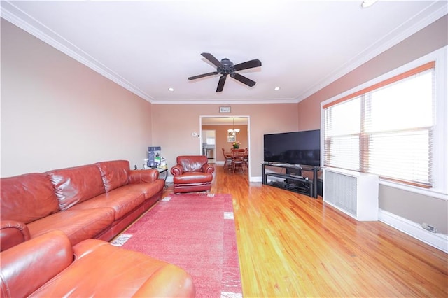 living area with crown molding, baseboards, a ceiling fan, and light wood-type flooring