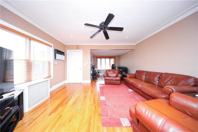 living area with light wood-style floors, radiator, ceiling fan, and ornamental molding
