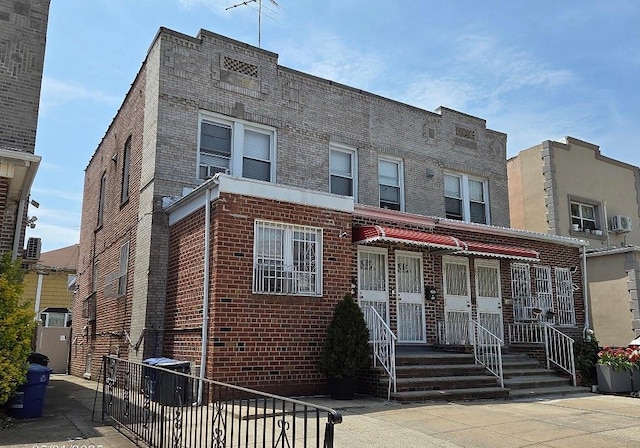 townhome / multi-family property featuring central air condition unit and brick siding