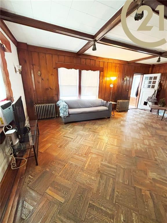 1817 E 15th St, Brooklyn, NY 11229 - living area featuring radiator heating unit, beam ceiling, and wood walls