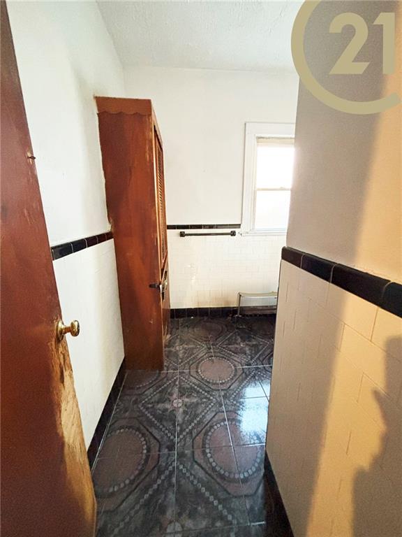1817 E 15th St, Brooklyn, NY 11229 - bathroom with tile patterned floors, a wainscoted wall, tile walls, and a textured ceiling