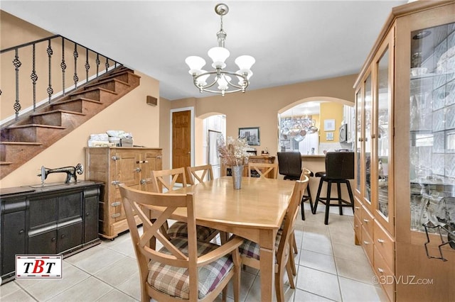 1854 73rd St, Brooklyn, NY 11204 - dining space featuring arched walkways, light tile patterned floors, a chandelier, and stairway