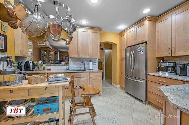 1854 73rd St, Brooklyn, NY 11204 - kitchen featuring freestanding refrigerator, arched walkways, backsplash, light tile patterned floors, and light stone countertops