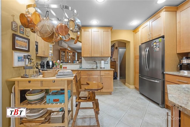 1854 73rd St, Brooklyn, NY 11204 - kitchen featuring freestanding refrigerator, arched walkways, light brown cabinetry, light tile patterned flooring, and tasteful backsplash