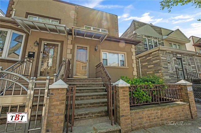 1854 73rd St, Brooklyn, NY 11204 - view of front of home featuring stucco siding, a fenced front yard, and a gate