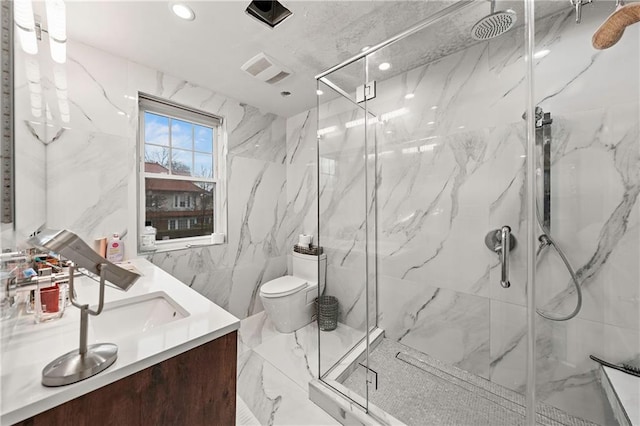 full bathroom featuring recessed lighting, double vanity, a marble finish shower, and toilet