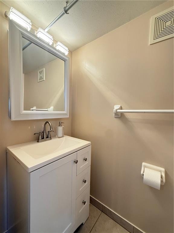 bathroom with tile patterned floors, baseboards, vanity, and visible vents