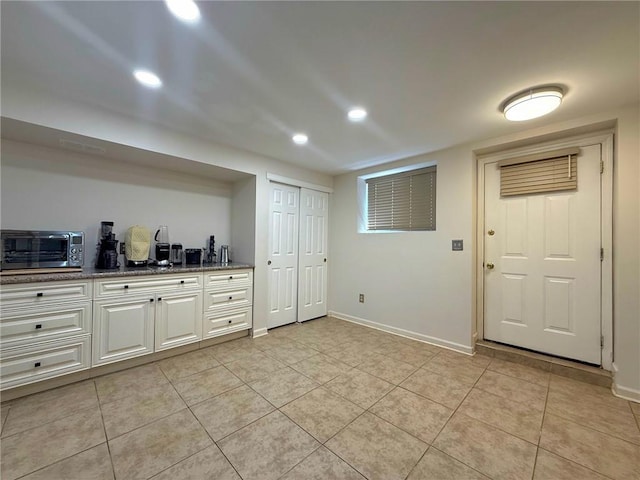 interior space featuring recessed lighting, baseboards, light tile patterned floors, and a toaster