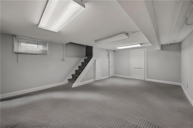 finished basement featuring carpet floors, stairs, and baseboards