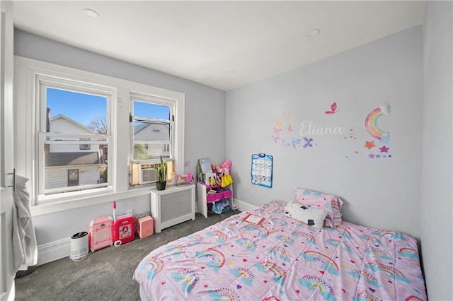 carpeted bedroom with baseboards, radiator, and cooling unit
