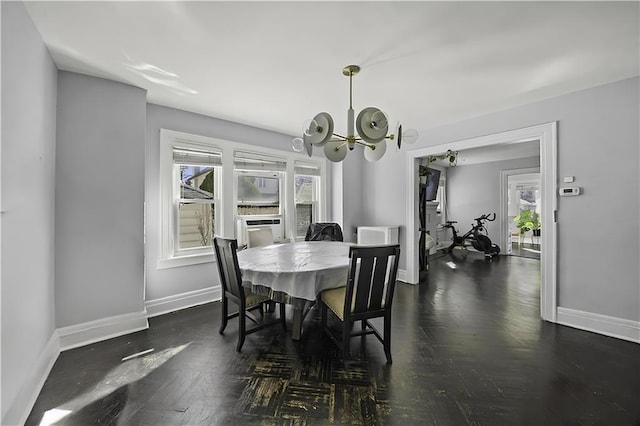dining area with an inviting chandelier, baseboards, plenty of natural light, and dark wood-type flooring