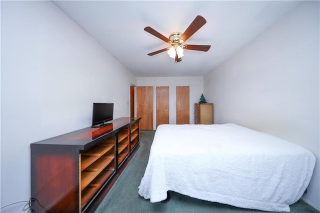 carpeted bedroom featuring ceiling fan and two closets