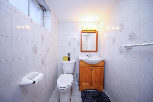 bathroom featuring vanity, tile patterned floors, toilet, and tile walls