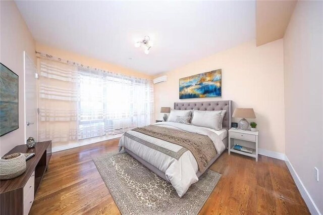 bedroom with baseboards and wood finished floors