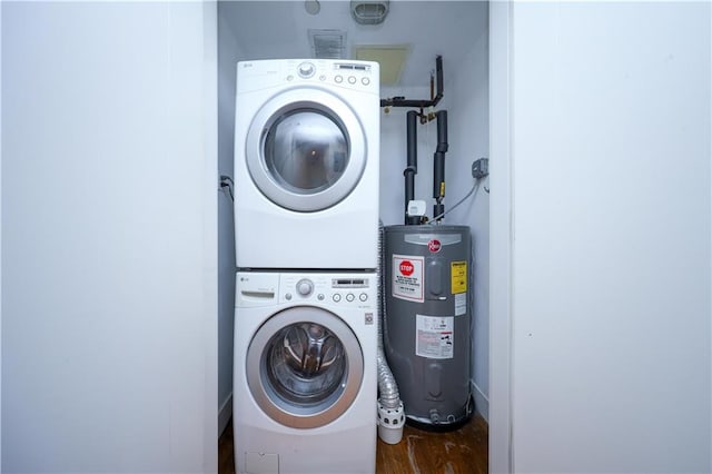 laundry area featuring laundry area, stacked washer and dryer, water heater, and wood finished floors