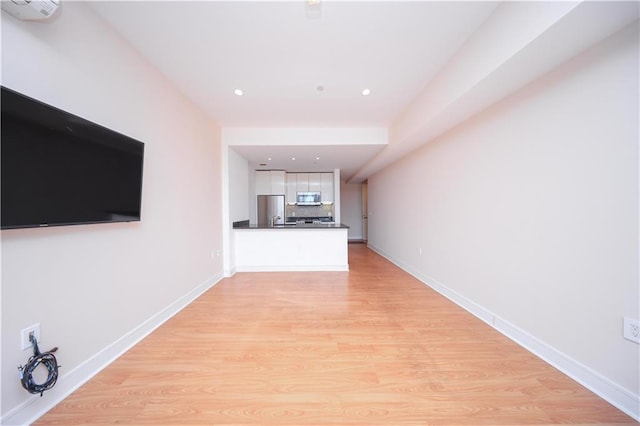 hallway with recessed lighting, baseboards, and light wood-style flooring