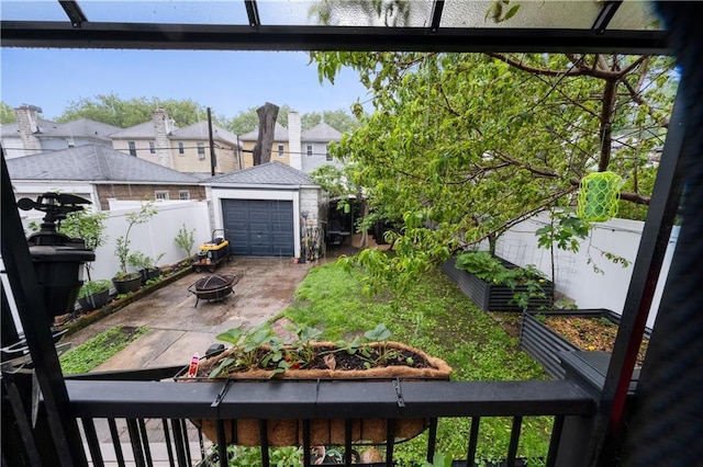 1942 Kimball St, Brooklyn, NY 11234 - fenced backyard with a fire pit, a garden, an outdoor structure, driveway, and a detached garage