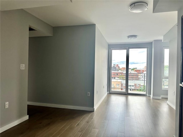 70-09 45th Ave Unit 7C, Woodside, NY 11377 - spare room with baseboards and dark wood-style floors