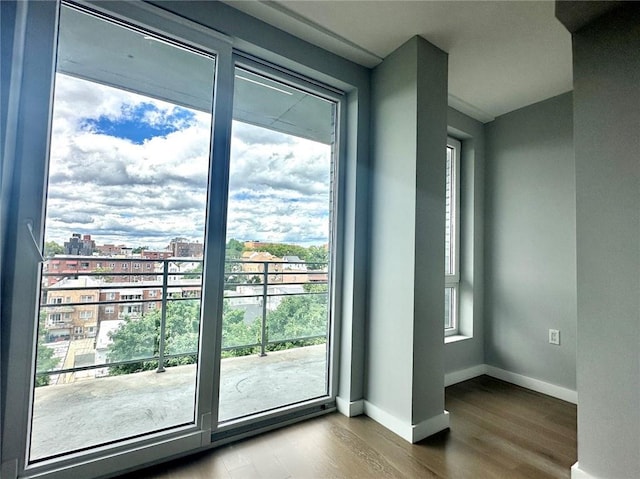 70-09 45th Ave Unit 7C, Woodside, NY 11377 - doorway featuring baseboards, a city view, plenty of natural light, and wood finished floors