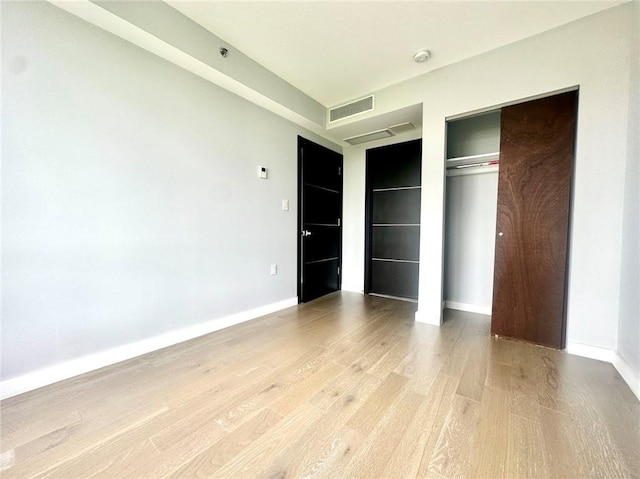70-09 45th Ave Unit 7C, Woodside, NY 11377 - unfurnished bedroom featuring a closet, light wood-style floors, visible vents, and baseboards