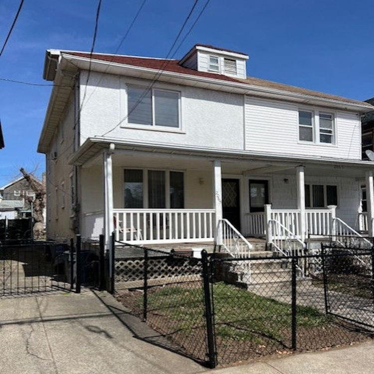 view of front of home featuring a gate, a fenced front yard, and a porch