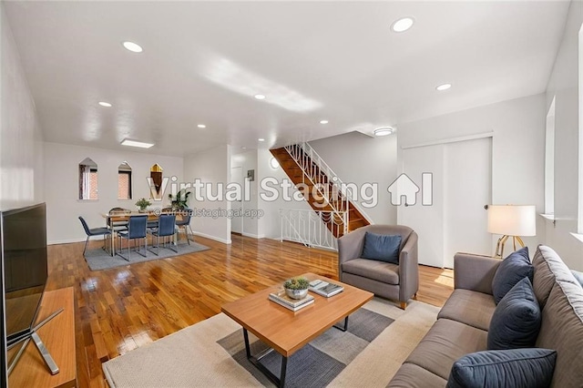 living room featuring stairway, baseboards, recessed lighting, and wood finished floors