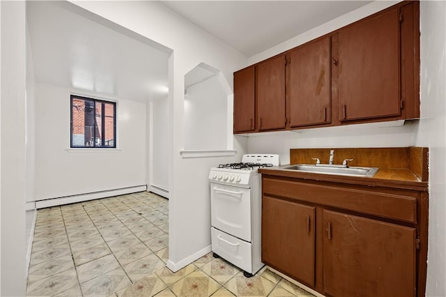 kitchen with baseboards, gas range gas stove, a baseboard radiator, baseboard heating, and a sink