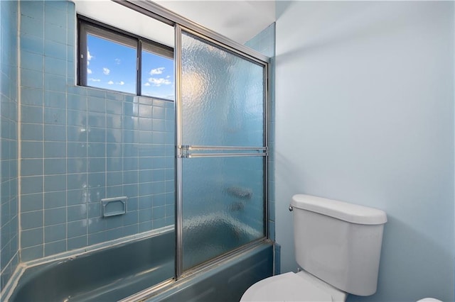 bathroom with shower / bath combination with glass door and toilet