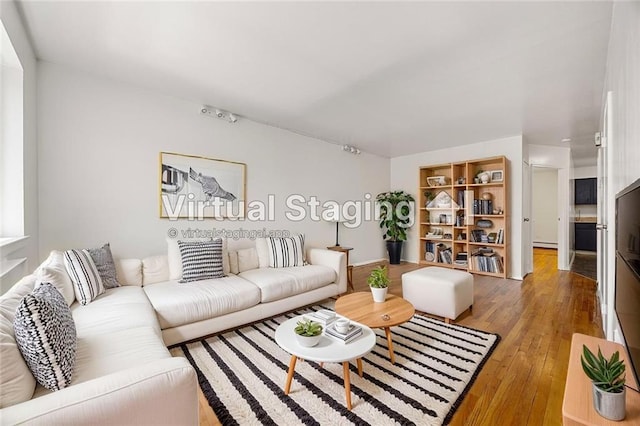 living area featuring baseboard heating and light wood-type flooring