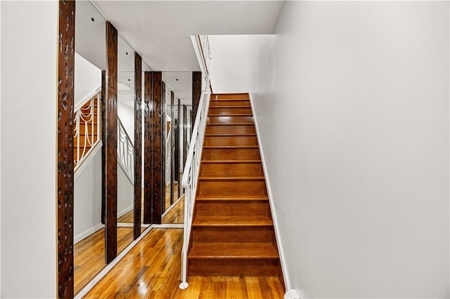 stairway featuring baseboards and wood finished floors