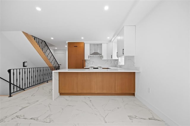 227 77th St, Brooklyn, NY 11209 - kitchen with recessed lighting, wall chimney range hood, light marble finish floors, a peninsula, and light countertops