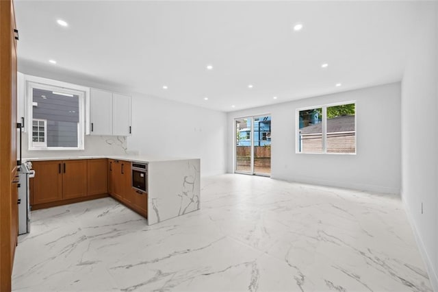 227 77th St, Brooklyn, NY 11209 - kitchen featuring light marble finish flooring, brown cabinetry, open floor plan, recessed lighting, and light countertops