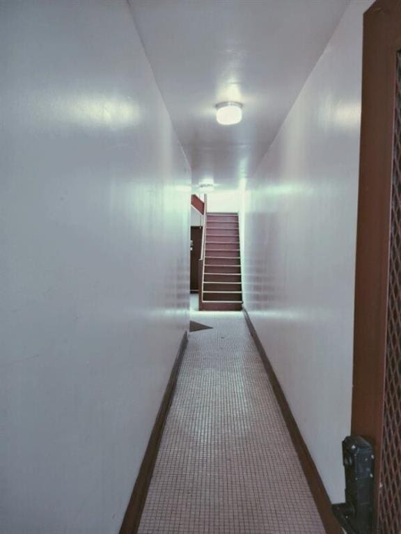 corridor with stairway, baseboards, and carpet