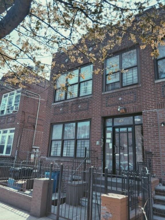 360 E 98th St, Brooklyn, NY 11212 - rear view of house featuring a fenced front yard, a gate, and brick siding