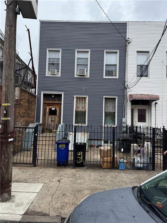 multi unit property with a fenced front yard and cooling unit