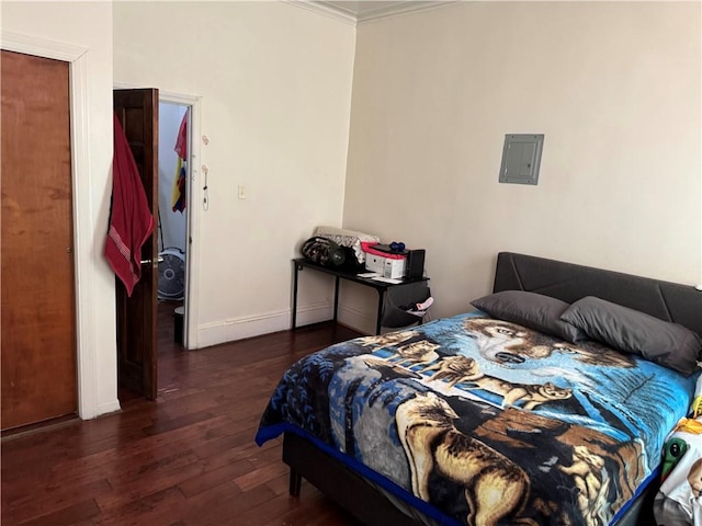 bedroom with baseboards, ornamental molding, hardwood / wood-style flooring, and electric panel