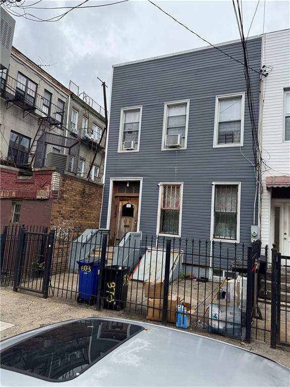 373 Bleecker St, Brooklyn, NY 11237 - view of property with a fenced front yard, cooling unit, and a gate